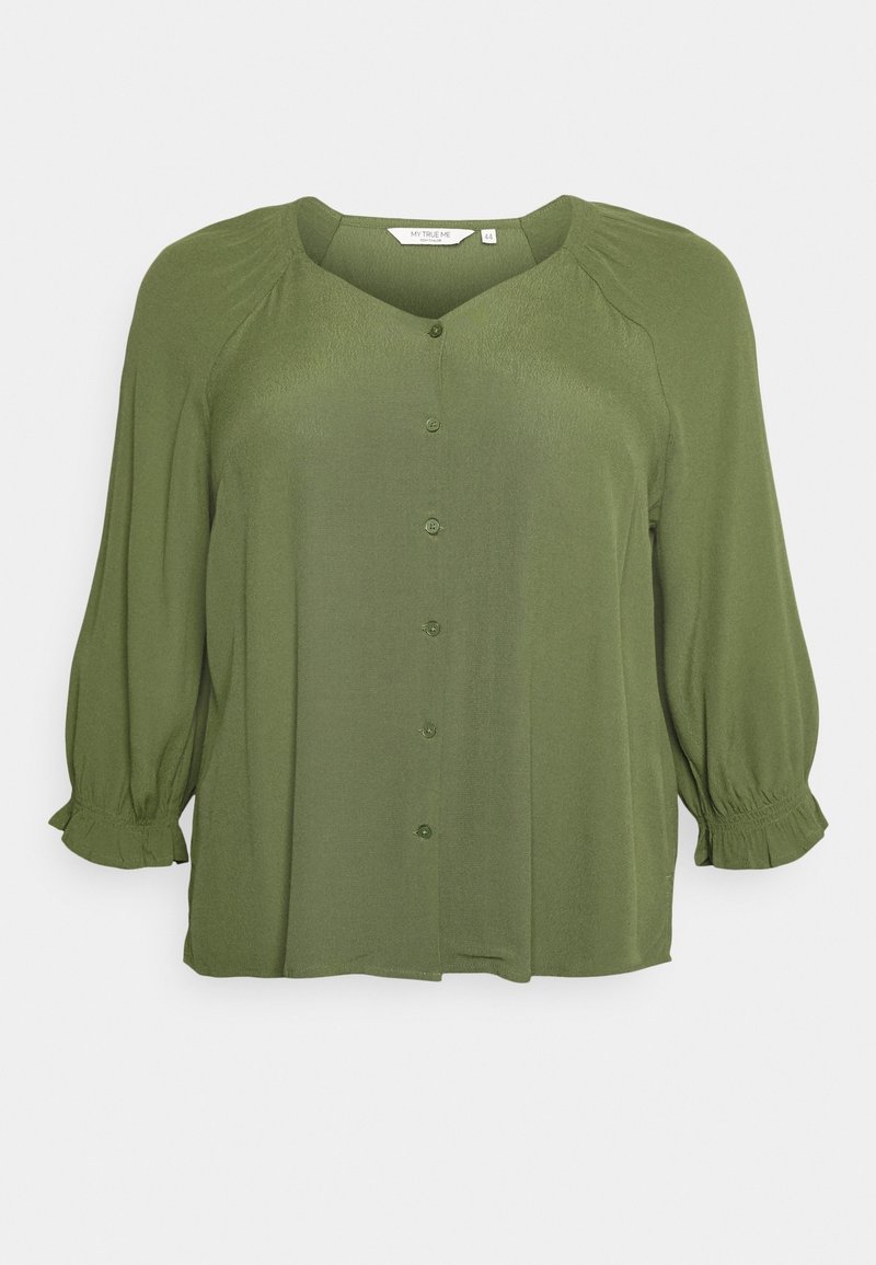 Blouse vert olive avec un col en V, boutons sur le devant et manches trois-quarts bouffantes. Présente des coutures d'épaule froncées et des poignets à volants.