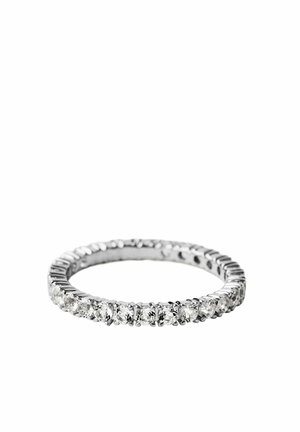 Delgado anillo de eternidad de plata con piedras preciosas claras y redondas alrededor de toda la banda sobre un fondo blanco.