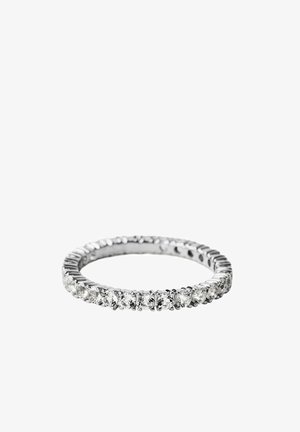 Delgado anillo de eternidad de plata con piedras preciosas claras y redondas alrededor de toda la banda sobre un fondo blanco.