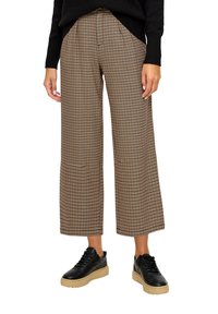 Gekleurde wijde broek in bruin, crème en zwarte tinten; geplooide voorkant; gecombineerd met zwarte sneakers met een chunky beige zool.