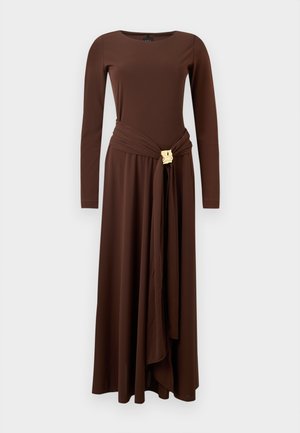 Καφέ φόρεμα με μακριά μανίκια, στρογγυλή λαιμόκοψη, λεπτομέρεια με ζώνη στο ύψος της μέσης και διακοσμητικό χρυσό αγκράφα, παρουσιασμένο σε απλό φόντο.