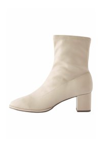Stivale alla caviglia beige con una silhouette elegante e aderente, punta appuntita e tacco a blocco. Realizzato in pelle liscia con sottili dettagli di cucitura.