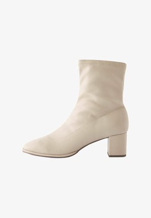 Beige ankle boot with a sleek, fitted silhouette, pointed toe, and block heel. Made of smooth leather with subtle stitching details.