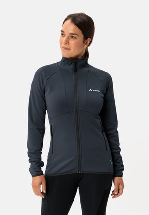 Veste zippée gris foncé avec un col montant, en tissu texturé, et deux poches latérales. Présente un logo blanc sur la poitrine et un accent vert au bas.