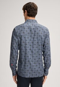 Heren overhemd met lange mouwen in donkerblauw met een geometrisch patroon in lichtblauw en zwart. Voorzien van een kraag, knopenmanchetten en een afgeronde zoom.