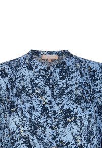Blå och marinblå mönstrad blus med rundad halsringning, knappstängning och mjukt tyg. Har ett abstrakt prickigt mönster med ljusa accenter.