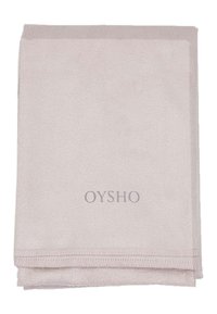 Světle růžový koupelnový ručník vyrobený z měkké, savé tkaniny. Obsahuje prošívaný okraj a vyšitý logo "OYSHO" v šedé barvě.