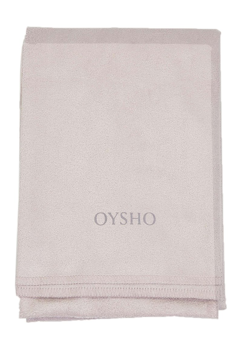 Světle růžový koupelnový ručník vyrobený z měkké, savé tkaniny. Obsahuje prošívaný okraj a vyšitý logo "OYSHO" v šedé barvě.
