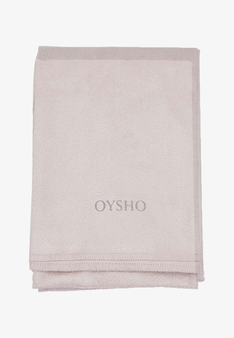 Světle růžový koupelnový ručník vyrobený z měkké, savé tkaniny. Obsahuje prošívaný okraj a vyšitý logo "OYSHO" v šedé barvě.