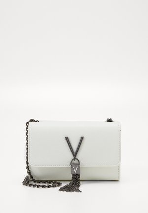 Witte leren clutch met zwarte metalen V-vormige sluiting en kettingfranje, met een zwarte ketting schouderriem op een witte achtergrond.