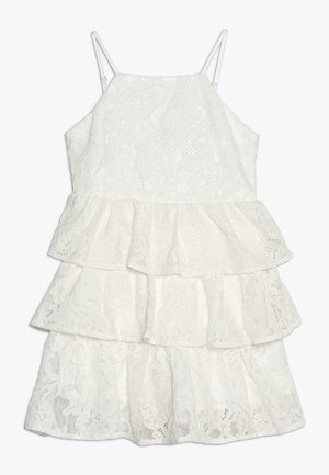 Hvid blonder, ærmeløs kjole med tynde stropper og tre-lags volangnederdel til piger eller kvinder.