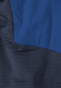 Tissu bleu marine avec deux textures ; un côté lisse et brillant, l'autre texturé avec un motif côtelé. Contraste de couleur distinctif.