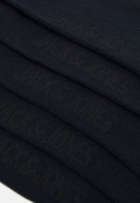 Black cotton socks stacked, featuring a textured surface with "JACK & JONES" printed in a matching dark shade on each sock.