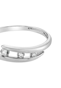 Bague en argent ouverte avec trois petites pierres précieuses rondes et transparentes disposées en rangée d'un côté.