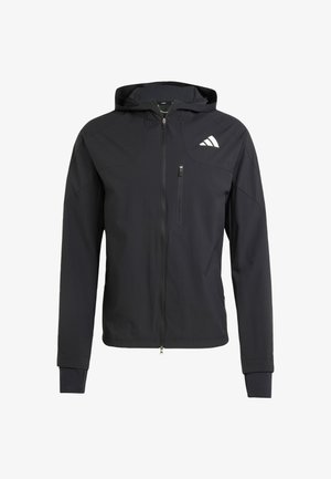 Chaqueta con capucha de color negro y cremallera, hecha de un tejido suave y ligero. Presenta un bolsillo en el pecho con cremallera y un detalle del logo en el lado superior izquierdo.