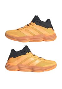 Zwei orange-schwarze, niedrige Sportschuhe mit dicken Sohlen und Mesh-Details, dargestellt aus der linken und rechten Seitenansicht.