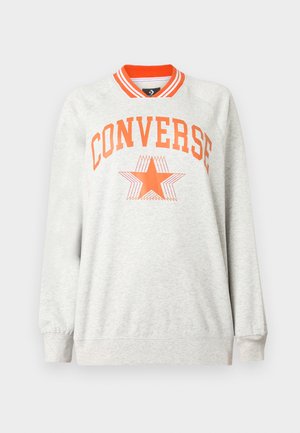 Lys grå hettegenser med lange ermer, oransje stripet krage og teksten "CONVERSE" samt stjerne-logo i oransje på brystet.