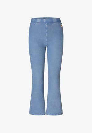 Jean flare taille haute bleu clair avec taille élastique et petit patch logo près de la hanche droite sur fond blanc.