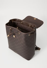 Sac fourre-tout à motif marron avec quincaillerie dorée, texture en cuir, fermeture à cordon, et un intérieur spacieux avec une poche zippée.