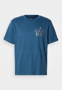 Μπλε βαμβακερή μπλούζα με κοντά μανίκια. Διαθέτει χρυσό λογότυπο "CALVIN KLEIN" στο μπροστινό μέρος. Κλασικός στρογγυλός λαιμός, λεία υφή.