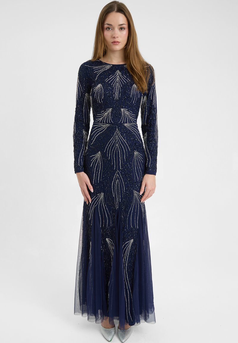 Abito da sera lungo con maniche lunghe di colore blu navy, caratterizzato da intricate perline argento e motivi floreali, con una gonna a strati trasparente e una silhouette aderente.
