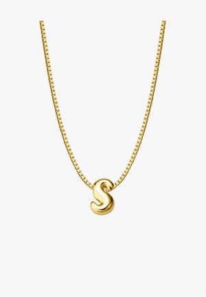 Zelta ķēdes kaklarota ar viļņainu burta "S" piekari. Dizains ir elegants, ar gludu tekstūru un atstarojošu virsmu.