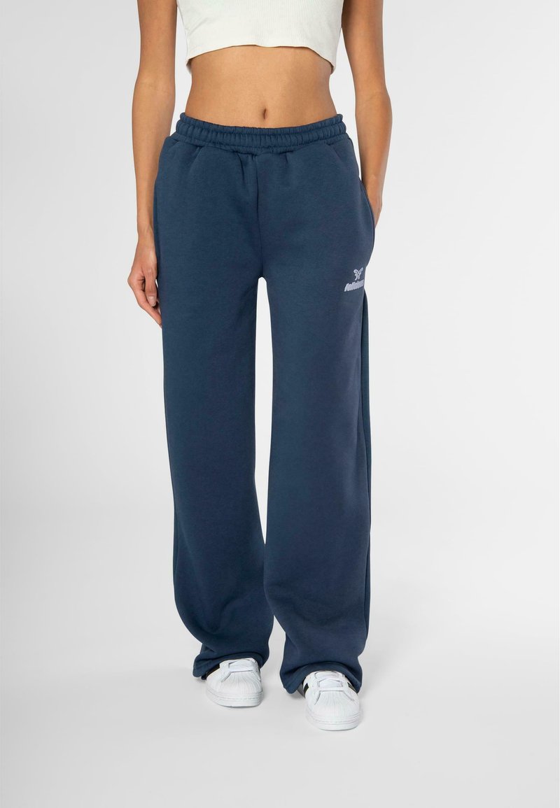 Pantalones de chándal de pierna ancha en azul marino, confeccionados en algodón suave, con cintura elástica y un pequeño logo impreso en blanco en el muslo izquierdo.
