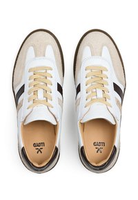 Weiße und beige Sneaker aus Wildleder und Leder. Mit cremefarbenen Schnürsenkeln, dunkelbraunen Akzenten und einer flachen Gummisohle.