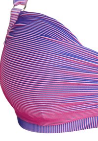 Close-up van een roze en paars gestreepte gewatteerde beha-cup met een verstelbare schouderband tegen een witte achtergrond.