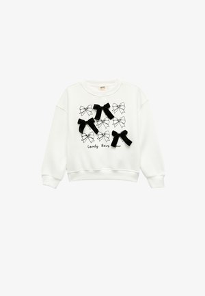Weißes Sweatshirt mit einem schwarz-weißen Schleifenmuster, das mit drei schwarzen Stoffschleifen auf der Vorderseite akzentuiert ist. Lange Ärmel, Rundhalsausschnitt.