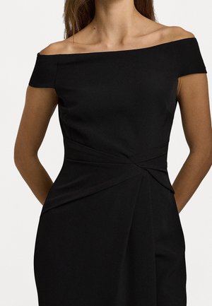 Svart axelbandslös klänning med en åtsittande bodice, draperad tyg och detalj med vridning vid midjan. Slät struktur, knälång design.