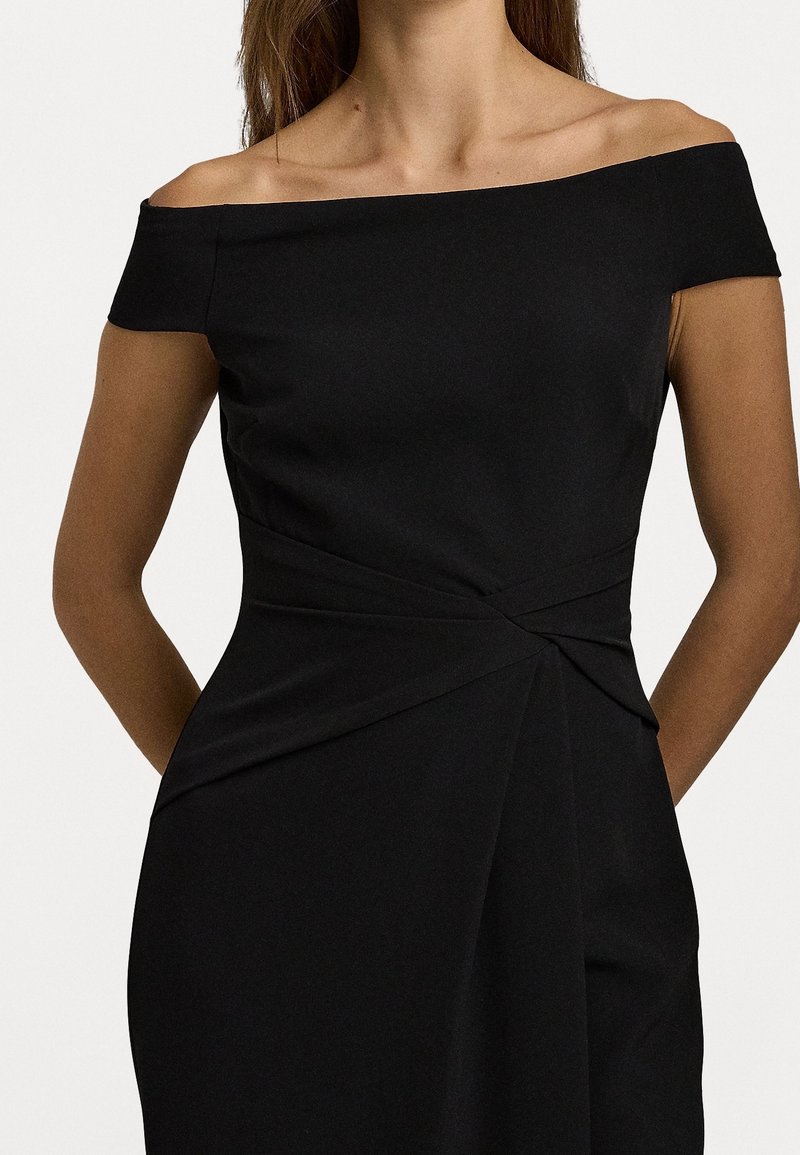 Černé šaty s odhalenými rameny, přiléhavým korzetem, draperií a detailním uzlem v pase. Hladká textura, délka po kolena.