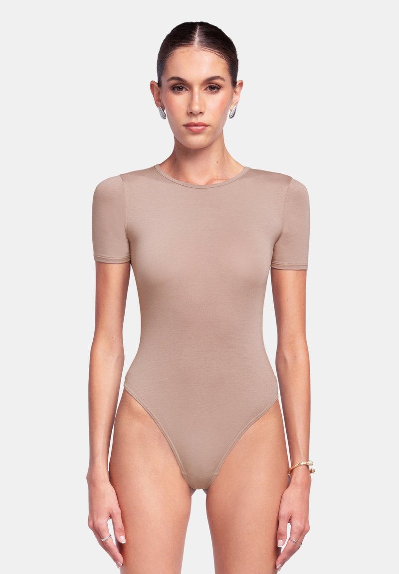 Body in tinta nude con maniche corte e scollatura rotonda. Presenta un design morbido e aderente con aperture alte sulle gambe. Texture del tessuto morbida.