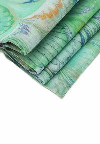 Tessuto leggero a fantasia con tonalità di verde, caratterizzato da vortici e linee arancioni e blu. Texture morbida, piegato ordinatamente.