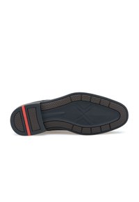 Semelle en caoutchouc noir avec un motif de grip texturé, dotée d'une bande d'accent rouge. Conçue avec une forme arrondie pour la stabilité et le confort.