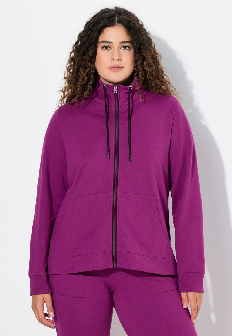 Fialová mikina na zip s předním zipem, vysokým límcem a dvěma předními kapsami; vyrobena z měkké tkaniny, s dlouhými rukávy a elastickými manžetami.