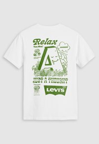 Balta kokvilnas T-krekls ar zaļiem grafikas tekstiem un ilustrācijām. Dizainā iekļautas frāzes "Atpūti savu prātu!" un "Tikai doma" ar stilizētu burtu "A".