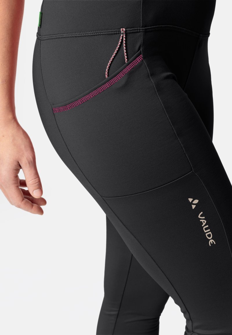 Schwarze Sportleggings mit glatter Textur, ausgestattet mit einer seitlichen Tasche in Pink und einem dezenten Logo an der Wade.