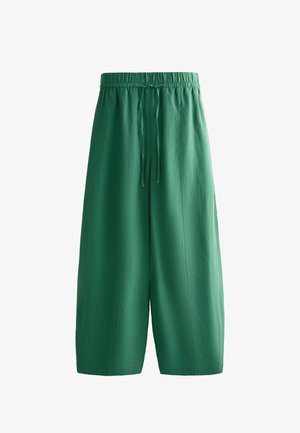 Zöld, bőszárú, rövidített nadrág rugalmas derékpánttal és elöl zsinóros megkötéssel.