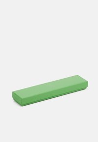 Zaļš putas jogas bloks ar taisnstūra formu, teksturētu virsmu un noapaļotiem stūriem. Aptuvenie izmēri ir 30 cm garums un 10 cm platums.