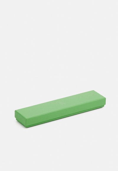Brique de yoga en mousse verte avec une forme rectangulaire, une surface texturée et des bords arrondis. Mesure environ 30 cm de long et 10 cm de large.
