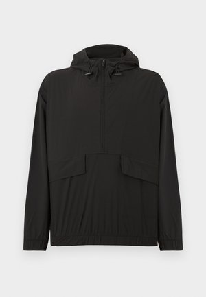 Zwarte waterdichte jas met een capuchon, halve rits aan de voorkant, elastische manchetten en twee zakken aan de voorkant. Soepele textuur en een losse pasvorm.