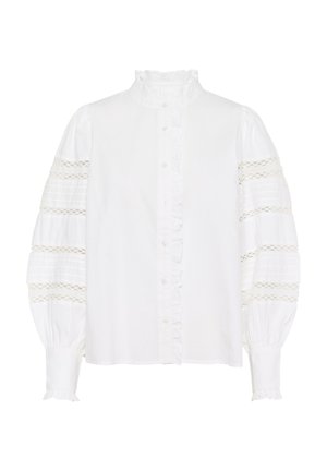 Camicia bianca con colletto alto arricciato, maniche a sbuffo testurizzate con dettagli in pizzo, e una pattina anteriore con piccoli bottoni.