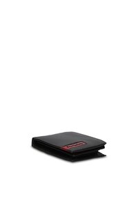 Portafoglio bifold in pelle nera con una targa con logo in metallo rosso e nero sulla parte anteriore, mostrato chiuso su uno sfondo bianco.