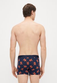Cuecas boxer azul-marinho com padrão de biscoitos de gengibre, cintura elástica com a etiqueta "HAPPY" e um design ajustado para conforto e suporte.