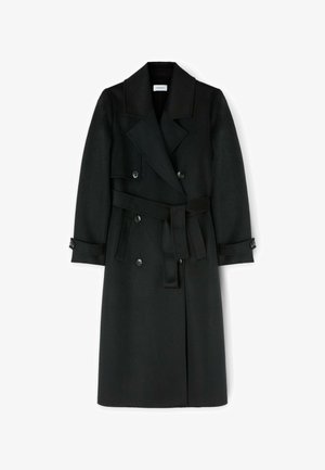 Černý vlněný trenčkot s dvouřadým zapínáním, širokými klopami a odnímatelným pásem; obsahuje knoflíkové manžety a délku ke kotníkům.