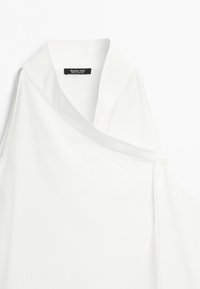 Biała bluzka bez rękawów z asymetrycznym kołnierzem i małym guzikiem na ramieniu, metka Massimo Dutti wewnątrz dekoltu.