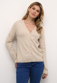 Beige knit cardigan with a V-neck, long sleeves, and subtle ribbed texture. Features a button-down front and a fitted design.