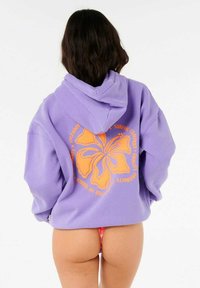 Pullover hoodie van lavendelkleurige stof, met een grote oranjehibiscusafbeelding op de achterkant, in een relaxte pasvorm en met capuchon.