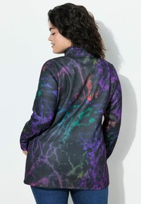Chaqueta negra de manga larga con un patrón texturizado que presenta rayas en púrpura, verde y naranja. Cuello alto y ajuste relajado.